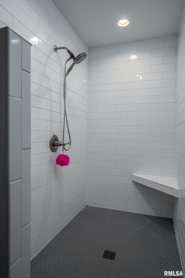 bathroom featuring tile patterned flooring and tiled shower