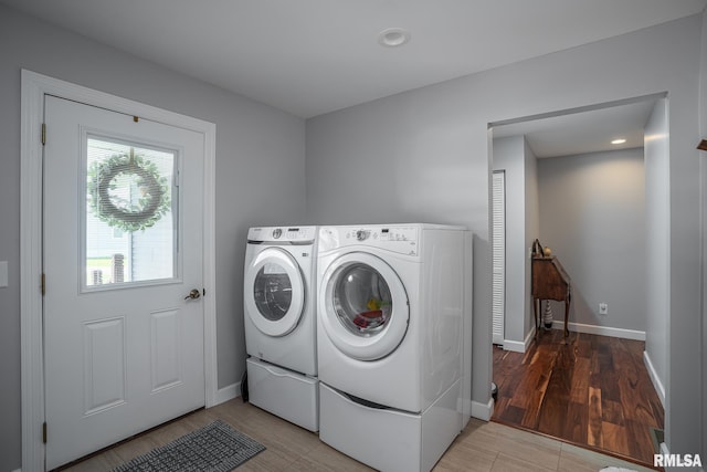 washroom with washer and clothes dryer and light hardwood / wood-style floors