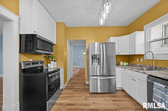 kitchen featuring white cabinets, appliances with stainless steel finishes, a textured ceiling, and sink