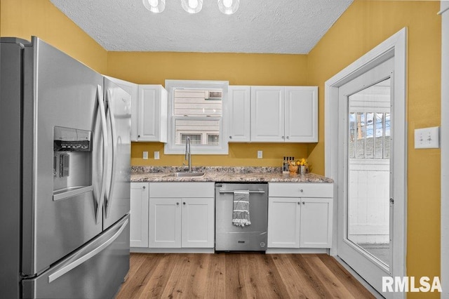 kitchen featuring a textured ceiling, white cabinetry, sink, and appliances with stainless steel finishes