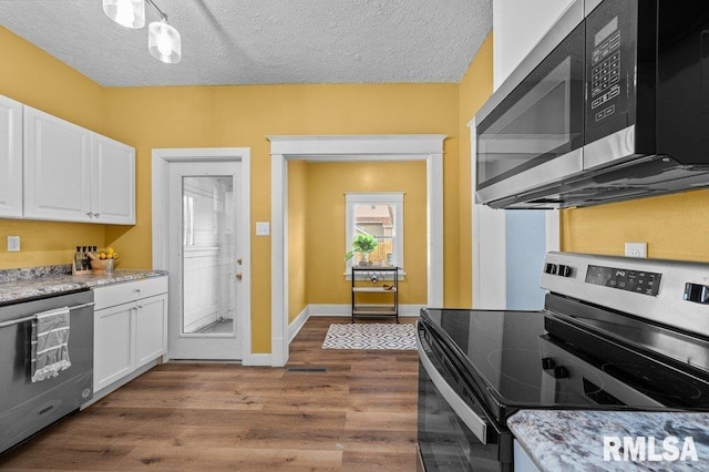 kitchen featuring white cabinets, dark wood-type flooring, a textured ceiling, and appliances with stainless steel finishes