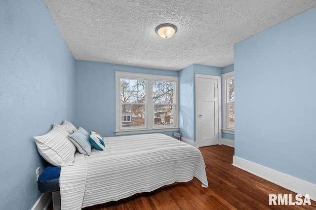 bedroom featuring a textured ceiling and dark hardwood / wood-style floors