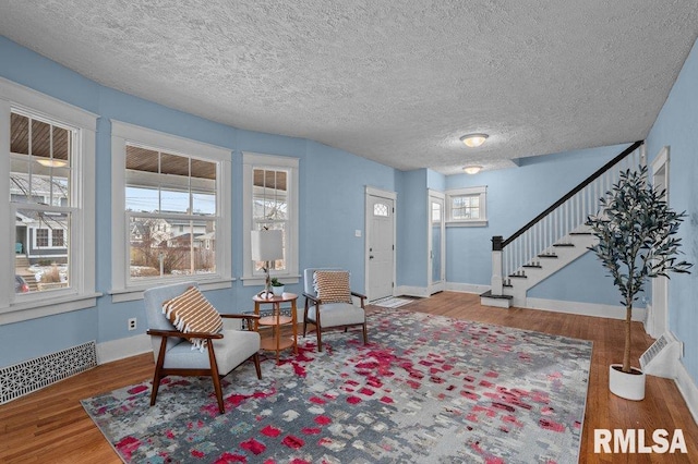 living area with wood-type flooring and a textured ceiling