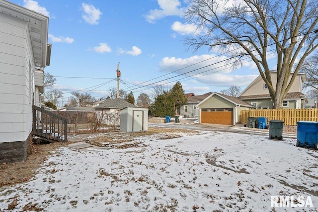 yard layered in snow with a storage unit