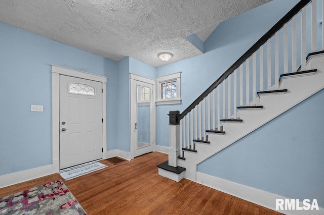 entryway featuring wood-type flooring and a textured ceiling