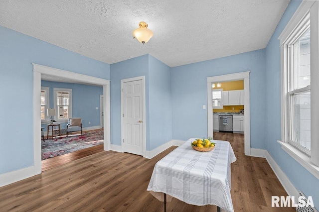 dining room featuring a textured ceiling, a wealth of natural light, and dark hardwood / wood-style floors