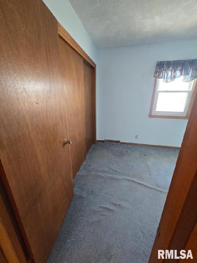 unfurnished room featuring carpet floors and a textured ceiling