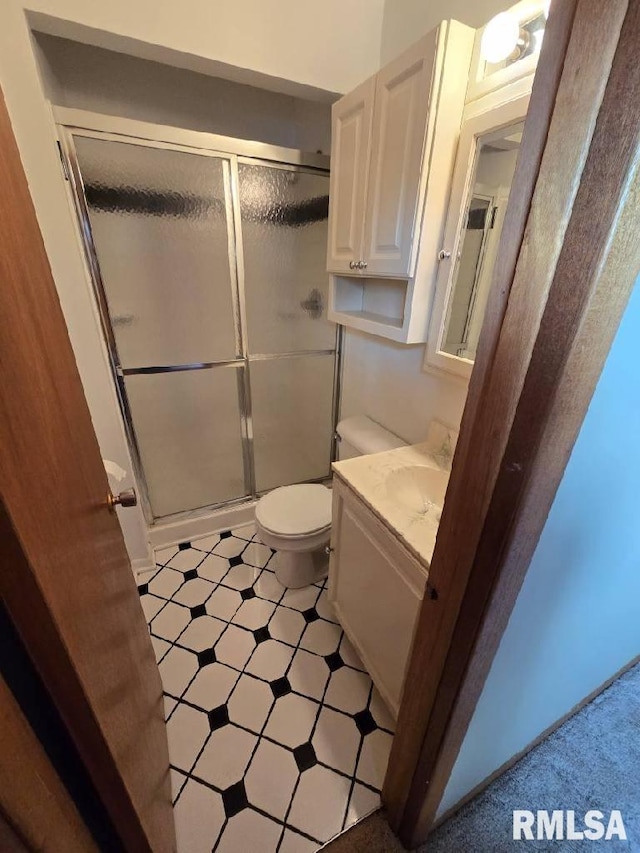 bathroom featuring vanity, toilet, and an enclosed shower