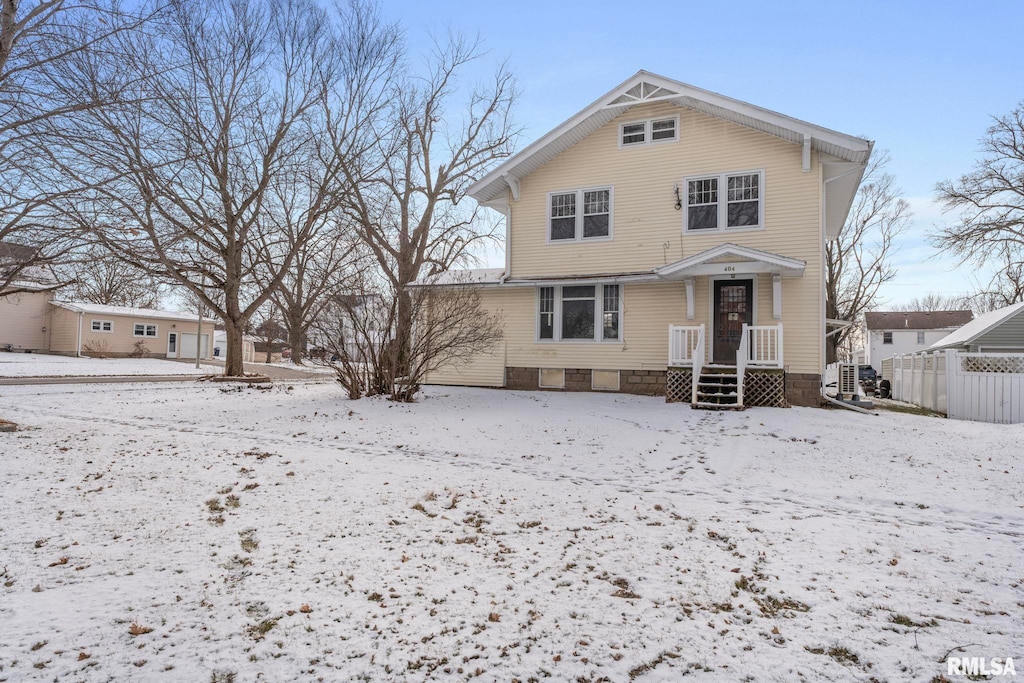 snow covered house with fence