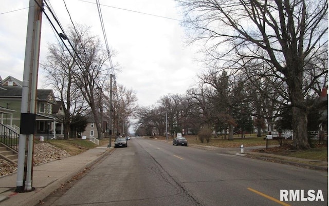 view of street with a residential view, curbs, and sidewalks