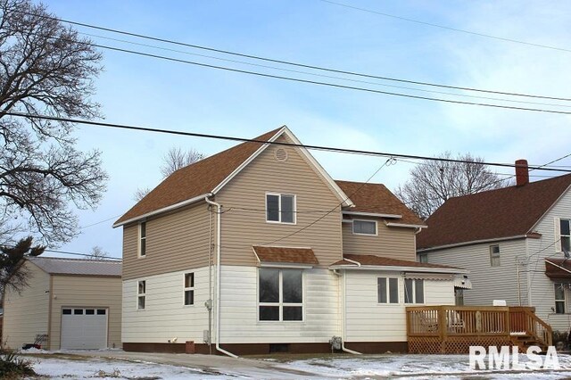 snow covered property featuring a garage and a deck