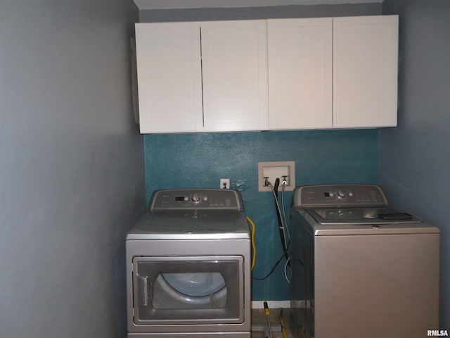 washroom with washer and dryer and cabinets