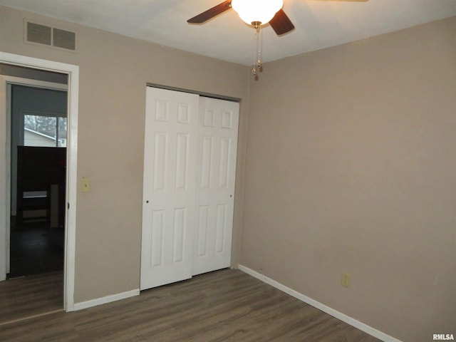 unfurnished bedroom with a closet, ceiling fan, and dark wood-type flooring