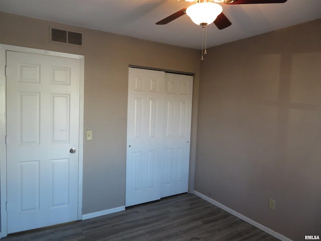 unfurnished bedroom featuring ceiling fan, dark wood-type flooring, and a closet