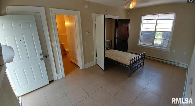 bedroom with light tile patterned flooring and a baseboard radiator