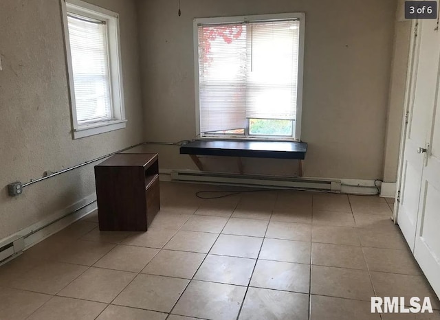 unfurnished dining area with light tile patterned floors and a baseboard radiator