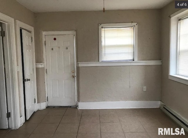 entrance foyer featuring tile patterned flooring, a wealth of natural light, and a baseboard radiator