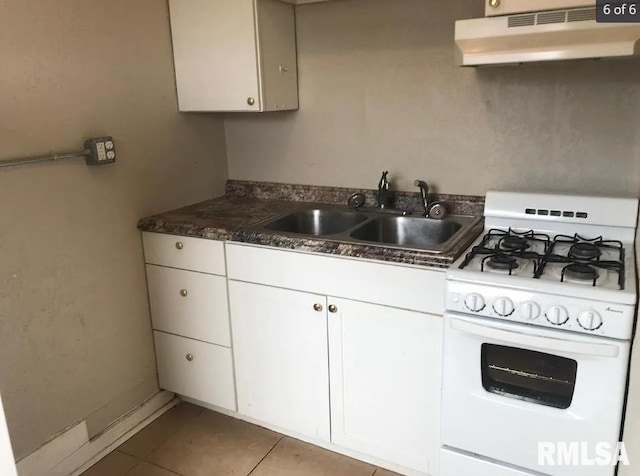 kitchen with tile patterned floors, extractor fan, sink, white cabinetry, and white range with gas cooktop