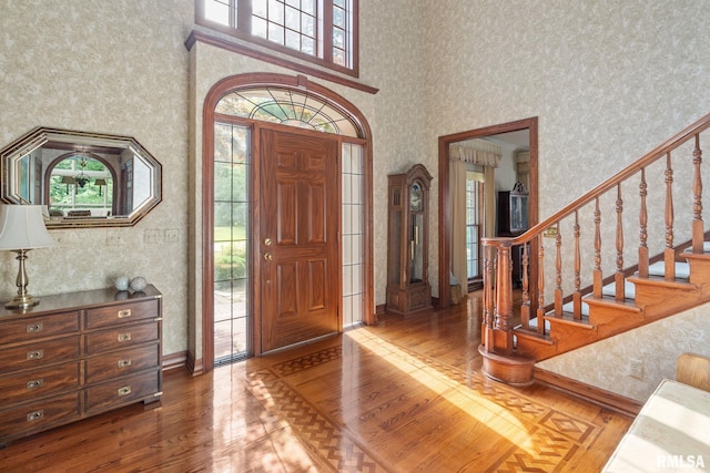 foyer featuring hardwood / wood-style floors, plenty of natural light, and a high ceiling