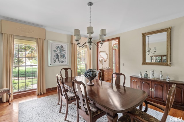 dining space with a healthy amount of sunlight, light hardwood / wood-style flooring, and a chandelier