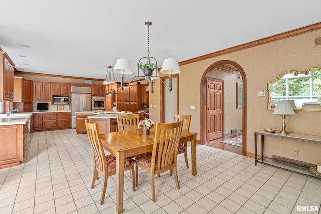 dining area with crown molding, sink, and an inviting chandelier