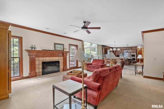 carpeted living room with a fireplace, plenty of natural light, crown molding, and ceiling fan