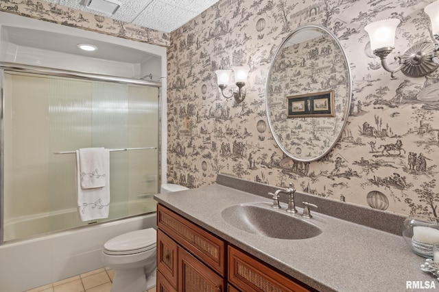 full bathroom with shower / bath combination with glass door, tile patterned flooring, vanity, and toilet