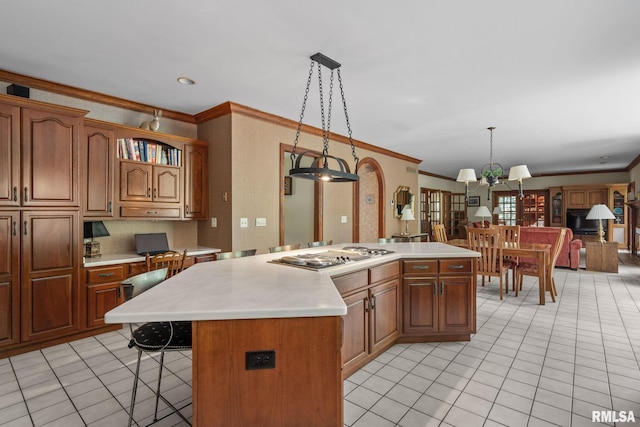 kitchen featuring a center island, crown molding, hanging light fixtures, and stainless steel gas cooktop