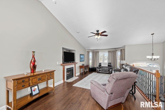 living room featuring dark hardwood / wood-style floors, lofted ceiling, and ceiling fan with notable chandelier