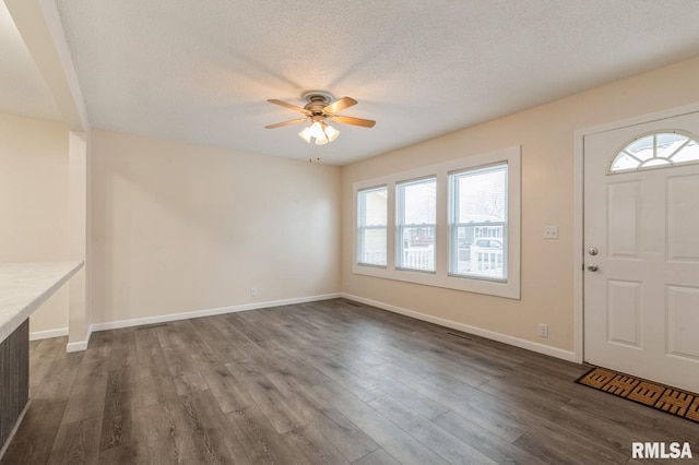 entrance foyer with ceiling fan, dark wood-type flooring, and a textured ceiling