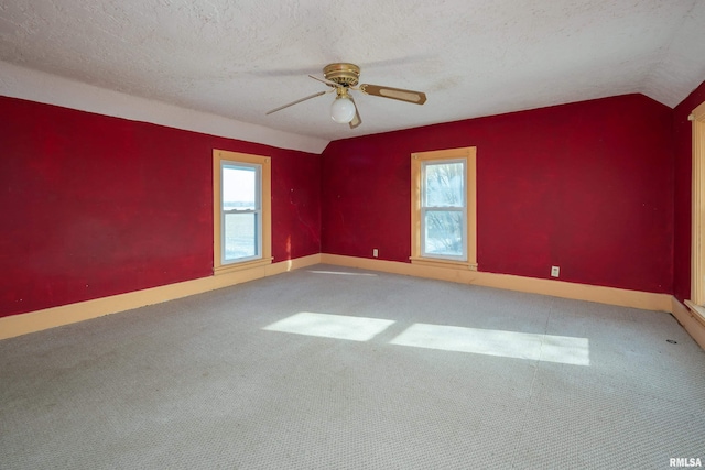 unfurnished room featuring carpet flooring, lofted ceiling, ceiling fan, and a textured ceiling