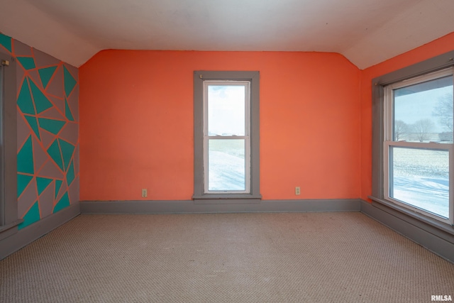 spare room with light colored carpet and vaulted ceiling