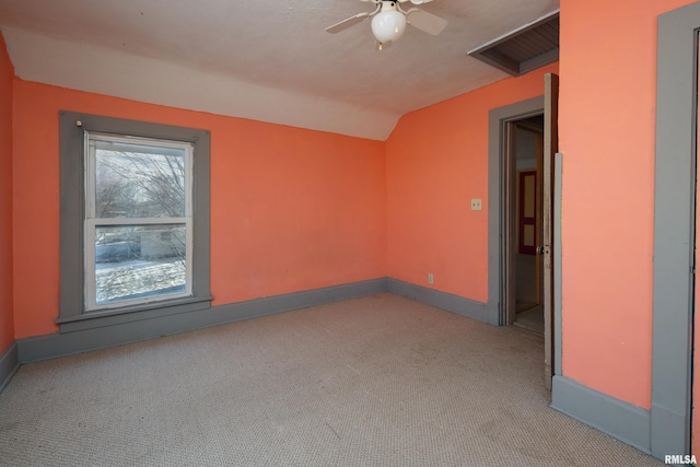 empty room featuring light colored carpet, vaulted ceiling, and ceiling fan