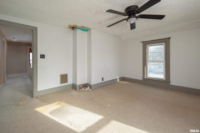 spare room with carpet flooring, ceiling fan, and a textured ceiling