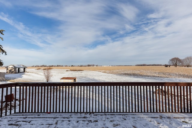 snow covered deck with a rural view