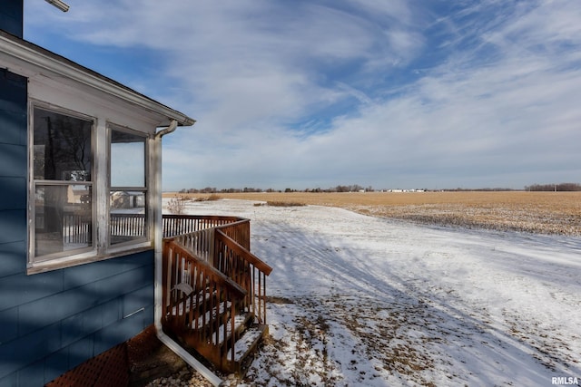 snowy yard featuring a rural view