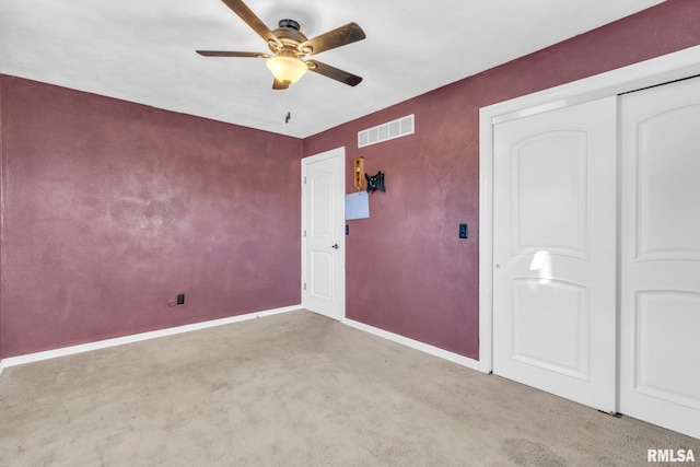 unfurnished bedroom with light carpet, a closet, and ceiling fan