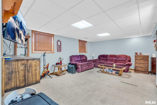 living room featuring carpet and a drop ceiling