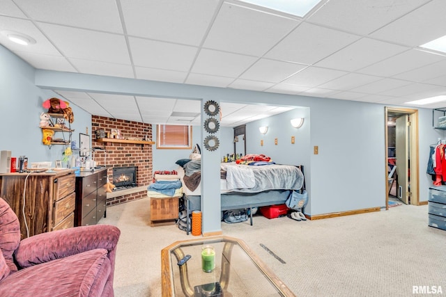 carpeted bedroom featuring a drop ceiling and a fireplace