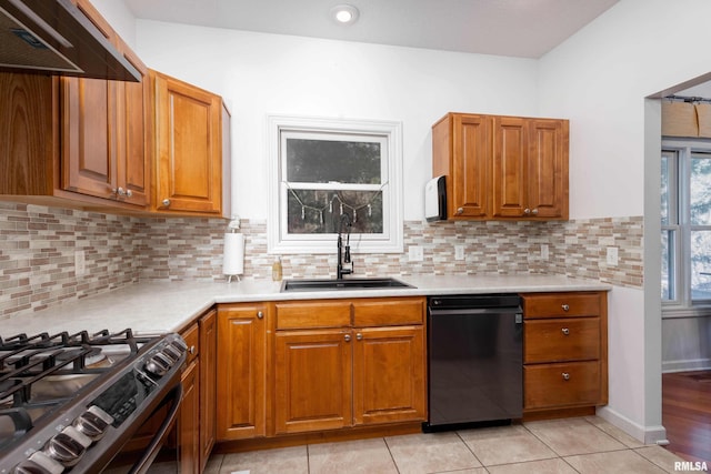 kitchen featuring dishwasher, decorative backsplash, sink, and light tile patterned floors