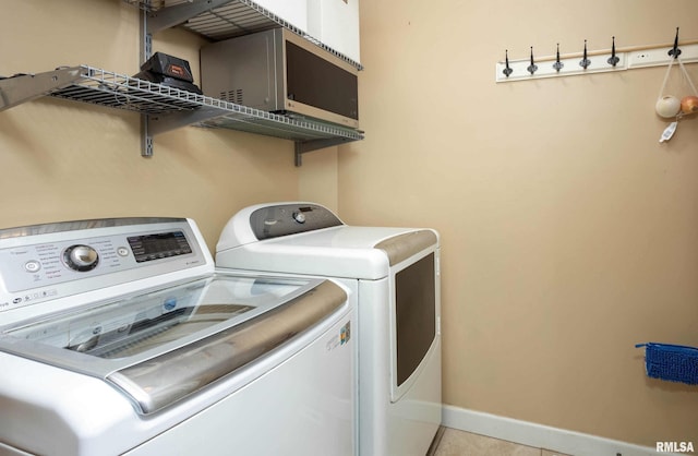 clothes washing area featuring light tile patterned floors and washing machine and dryer