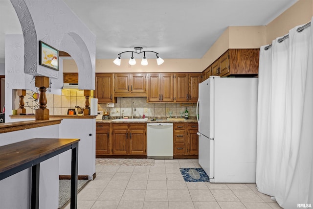 kitchen with decorative backsplash, white appliances, sink, and light tile patterned floors