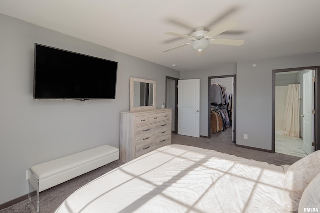 carpeted bedroom with ensuite bathroom, ceiling fan, a walk in closet, and a closet