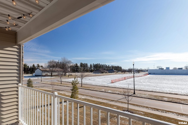 yard covered in snow featuring a balcony