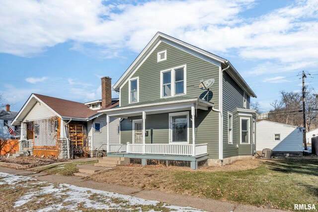 view of front of property featuring covered porch, central AC, and a front yard