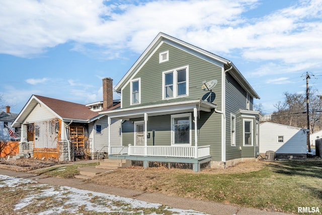 view of front of property featuring covered porch, central AC, and a front yard