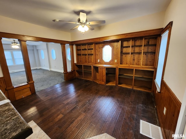 unfurnished living room with ceiling fan and dark wood-type flooring