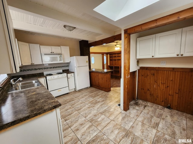 kitchen with beam ceiling, white cabinetry, sink, and white appliances