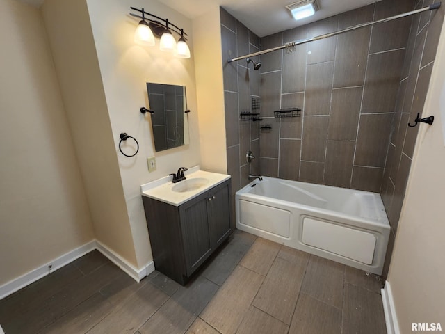 bathroom with tiled shower / bath combo and vanity