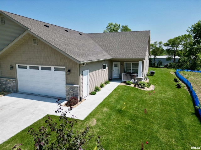 view of front of house with a porch, a garage, and a front lawn